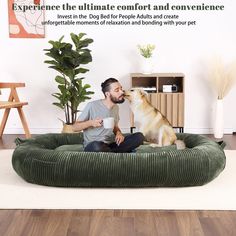 a man is sitting on the floor with his dog and drinking from a coffee cup