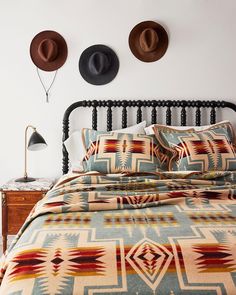 a bed with two hats on the wall above it