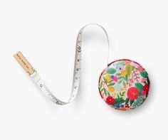 a measuring tape is next to a flowered round case