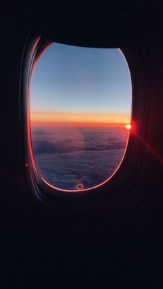 the view out an airplane window at sunset