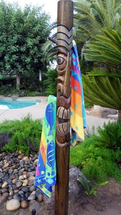 a wooden pole with a towel hanging from it's side next to a pool