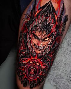 a man's leg with an evil face and demon tattoo on the side of his arm