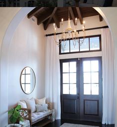 a living room with a couch and a chandelier hanging from the ceiling above it