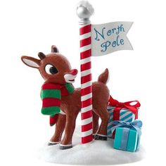 a christmas ornament with a reindeer holding a pole and presents on the ground