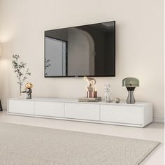 a flat screen tv mounted to the side of a white entertainment center in a living room