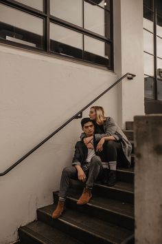 a man and woman sitting on some steps