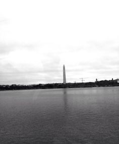 black and white photograph of the washington monument from across the water in washington, dc