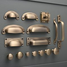 an assortment of handles, knobs and pulls on a gray surface with metallic paint