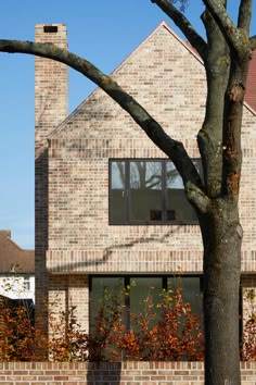 a brick house with a tree in front of it