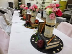 there are many books on the table with flowers in vases next to each other