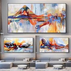 three large paintings hanging on the wall in a living room with couches and chairs