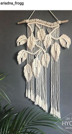 a wall hanging made out of macrame and palm leaves