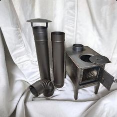 three different types of cooking utensils sitting on a white cloth covered tablecloth