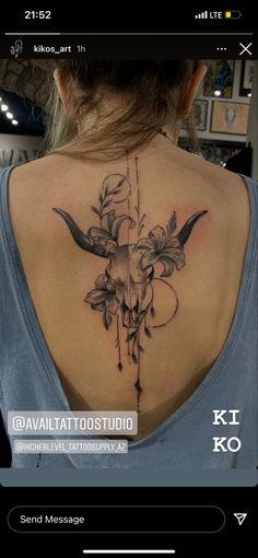 the back of a woman's neck with flowers and an animal skull on it