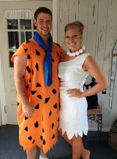 a man and woman dressed up as flint and the flintstones for halloween costume contest