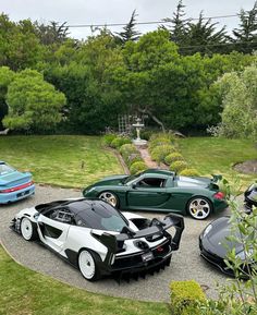 four exotic sports cars parked in a driveway