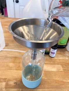 a person pouring water into a glass container