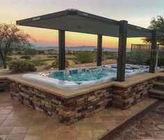 a hot tub sitting on top of a stone patio