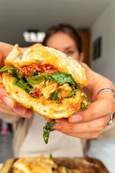 a woman holding up a sandwich in her hands