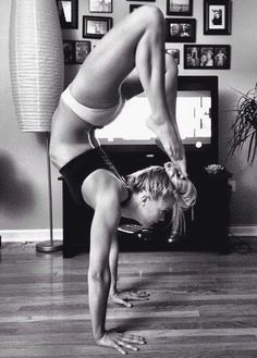 a woman doing a handstand in front of a tv