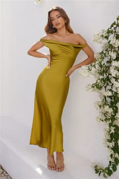 a woman in a yellow dress posing for the camera with her hands on her hips