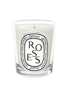 a glass candle with the words roses on it