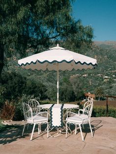 an outdoor table and chairs with an umbrella