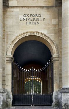 an entrance to the oxford university press building with wrought iron gates and arched doorways