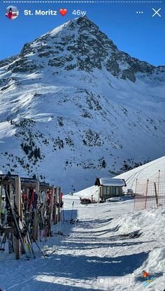 there are many skis lined up in front of the snow covered mountain side house