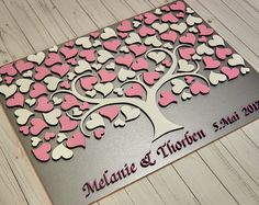 a wedding guest book with pink and white hearts in the shape of a family tree