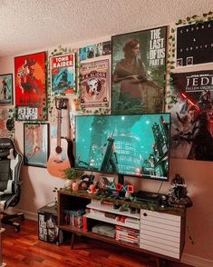 a living room with posters on the wall and a computer desk in front of it