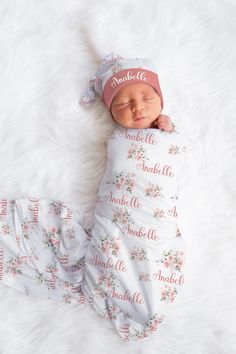 a newborn baby wearing a pink hat and swaddled blanket