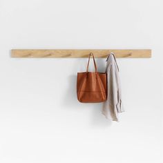 a leather bag hanging on a wooden coat rack