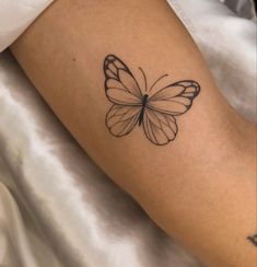 a small butterfly tattoo on the arm