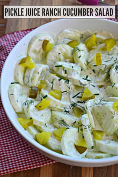 pickle juice ranch cucumber salad in a white bowl on a red and white checkered napkin