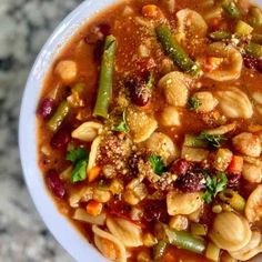 a white bowl filled with pasta and vegetables