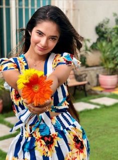 a woman holding a flower in her hand