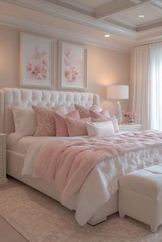 a large white bed sitting in a bedroom next to a window with pink flowers on it