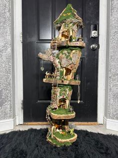 a tall tower made out of fake trees in front of a door