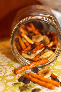 a glass jar filled with sliced bananas and chocolate chips on top of a floral table cloth