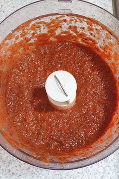 a food processor filled with red sauce on top of a counter