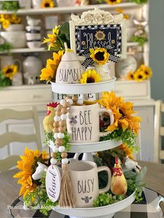 three tiered tray with coffee mugs and sunflowers