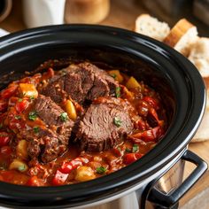 a slow cooker filled with meat and vegetables