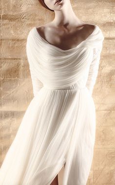 a woman in a white dress posing for the camera