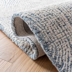 a close up of a rug on the floor with wood floors in the foreground