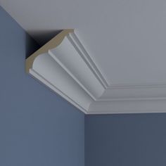 the corner of a room with blue walls and white molding on the ceiling is shown