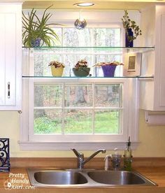 a kitchen sink sitting under a window next to a stove top oven