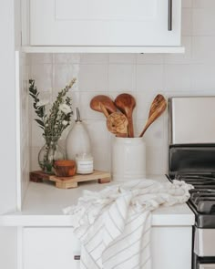 a kitchen counter with utensils on it and a towel draped over the stove