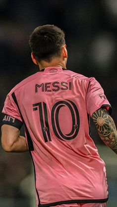 a soccer player with tattoos on his arm and chest, wearing a pink shirt that says mess