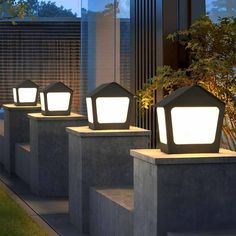 three outdoor lights on concrete blocks in front of a building